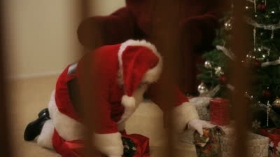 stock-footage-santa-clause-putting-gifts-under-the-christmas-tree